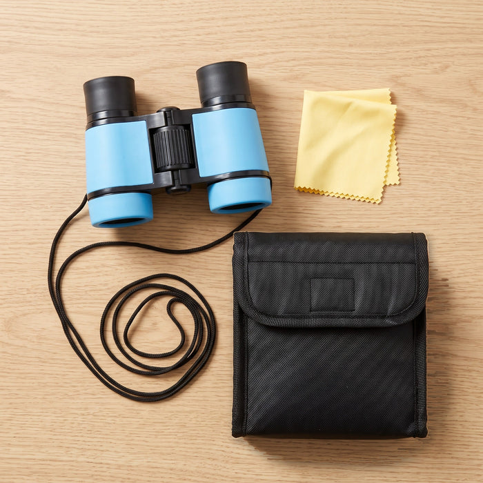 The binoculars with their neck strap, a yellow cleaning cloth and a black carry pouch, laid out on a table