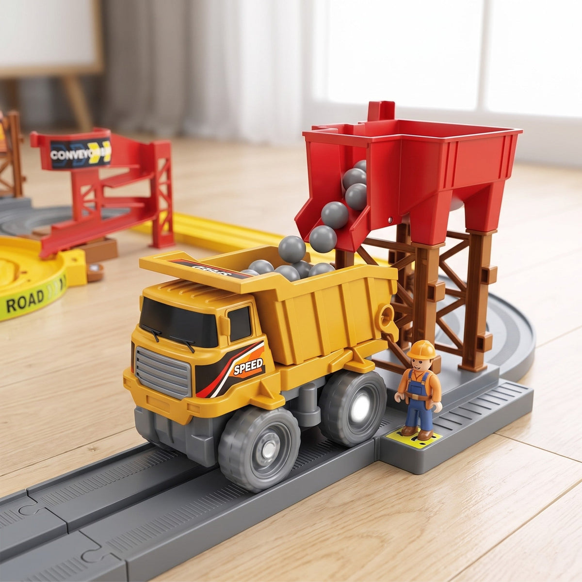 Close-up of grey balls pouring from the red loading station into the yellow dump truck, with a small worker figure beside it