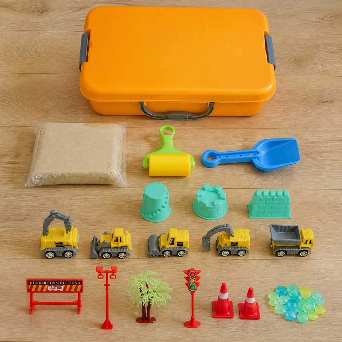 In the set: orange case, sand, roller, shovel, 3 castle molds, 5 toy trucks, road signs, palm tree, 2 cones and clear stones
