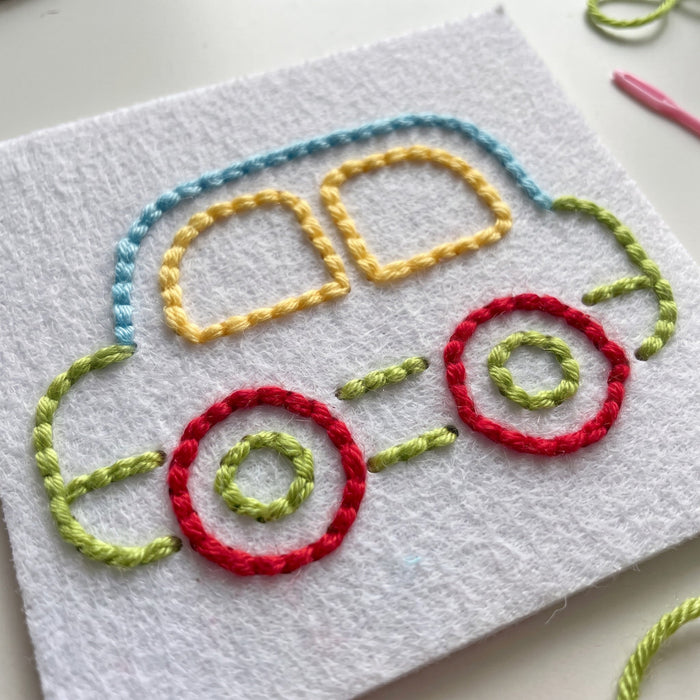 A finished car stitched on a felt card in blue, yellow, green and red thread